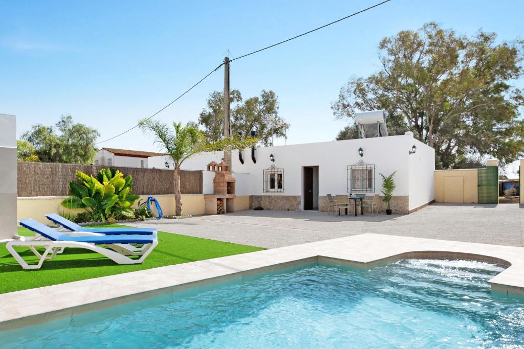 a backyard with a swimming pool and a house at Villa Montenmedio 1 in El Soto