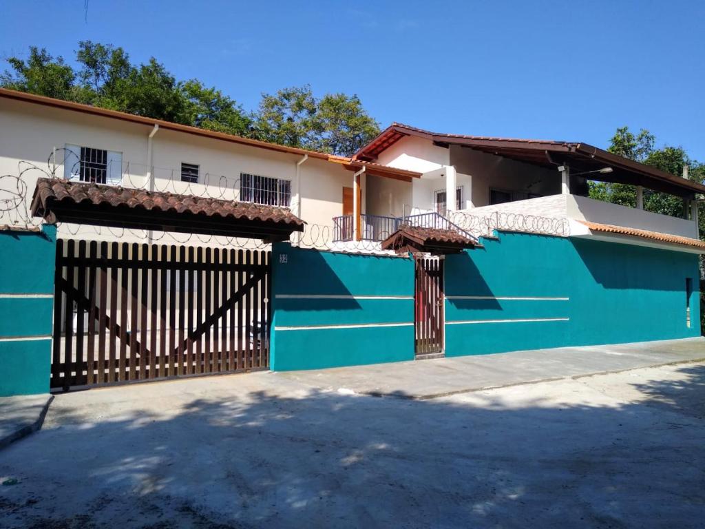 a blue fence in front of a house at Chalés Bielle de Ubatuba in Ubatuba