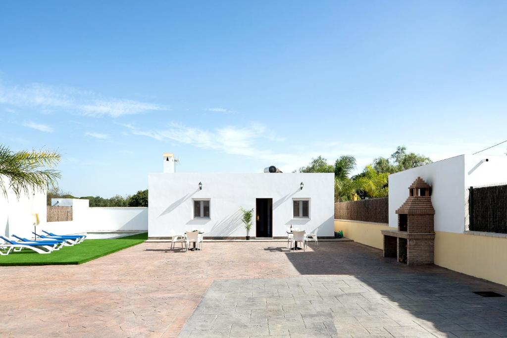 una casa bianca con patio e cortile di Villa Montenmedio - Carmelo a El Soto