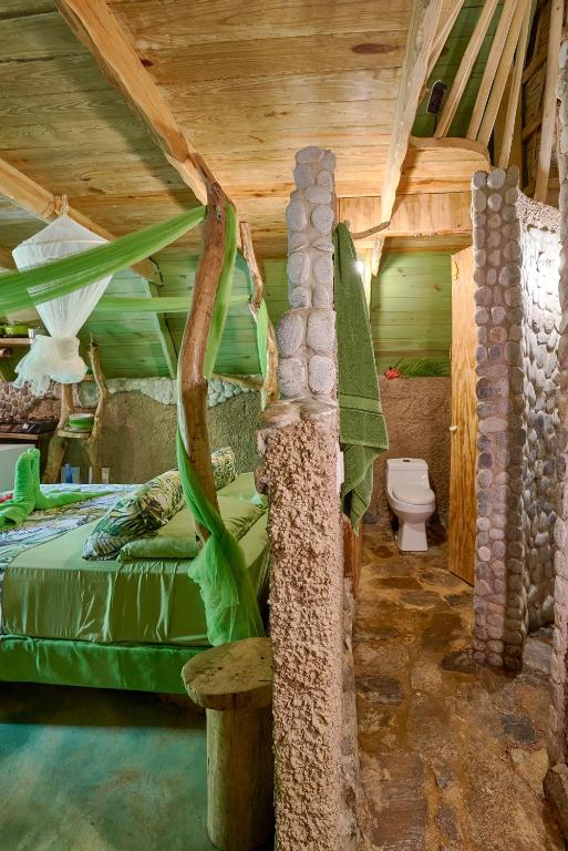 a bedroom in a tree house with a bed and a toilet at CHALET TROPICAL Hotel & Restaurant-Pizzeria in Las Galeras