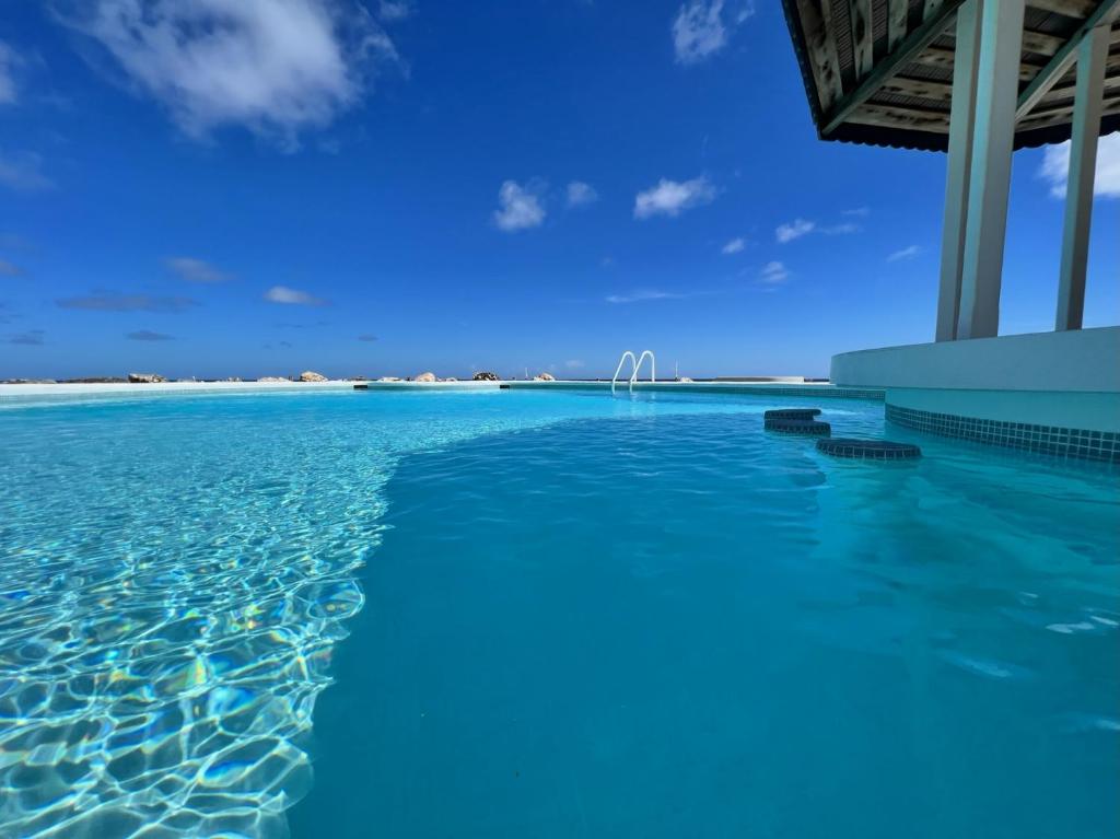 a swimming pool in the ocean with a beach in the background at OceanBlue Resort in Christ Church