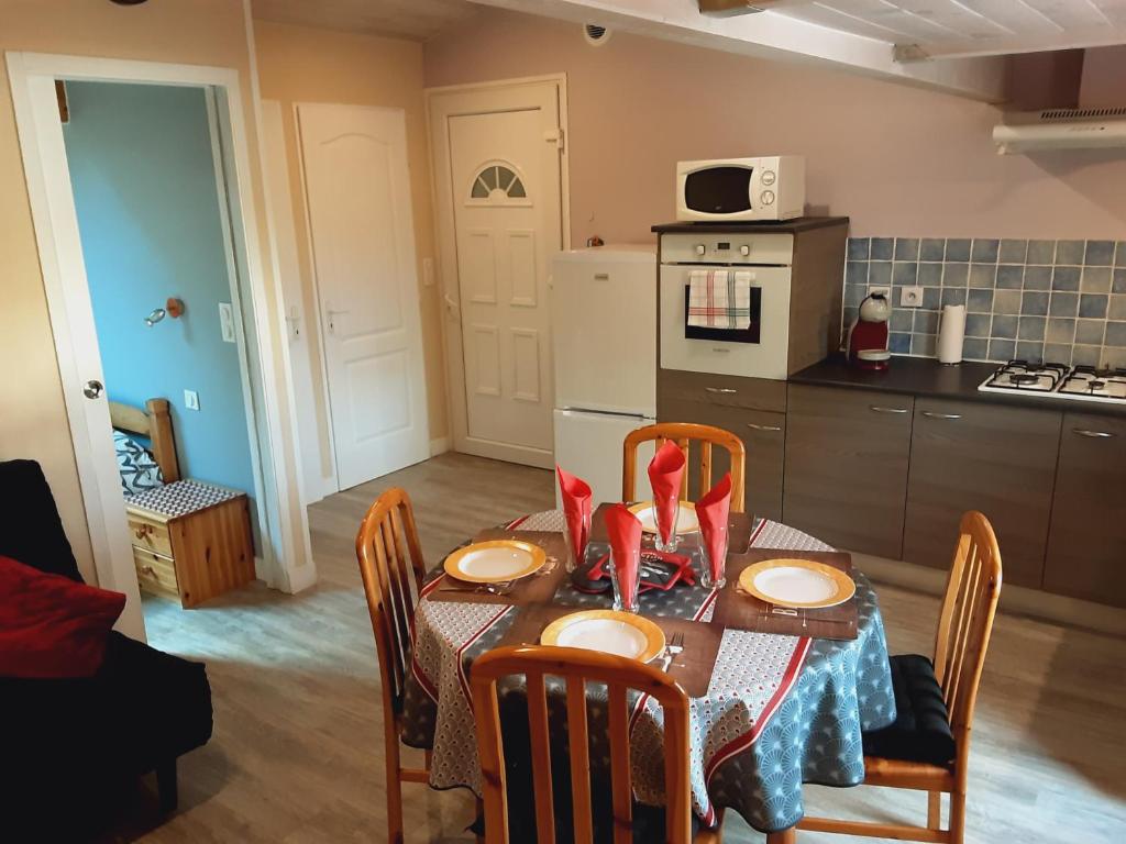 Prigonrieux的住宿－Coquet T2 avec parking，带桌椅的厨房以及带桌子和桌子的厨房。