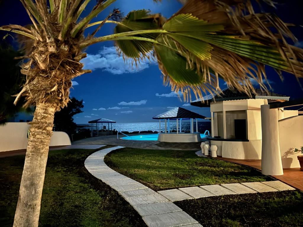 a palm tree in front of a villa at OceanBlue Resort in Christ Church