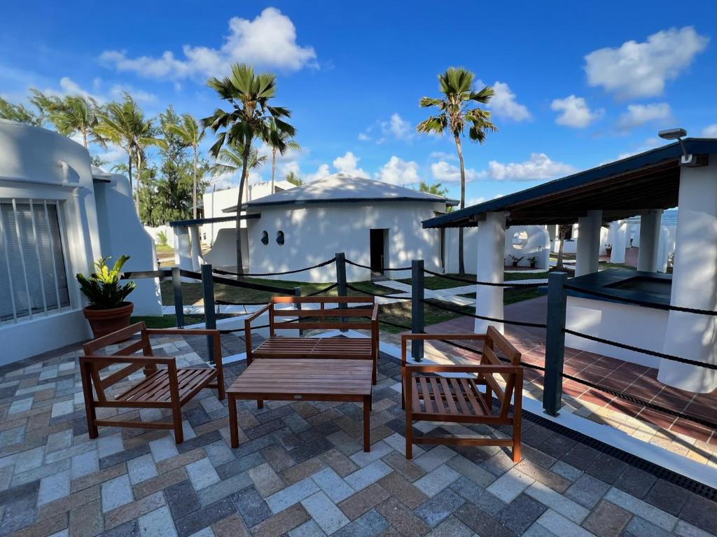a patio with chairs and a table on a house at OceanBlue Resort in Christ Church