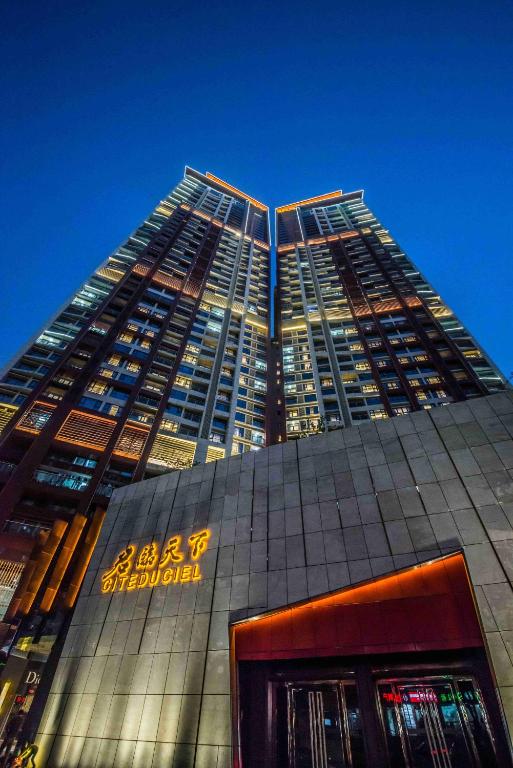 深圳深圳盛捷君临天下服务公寓的一座前面有标志的高楼