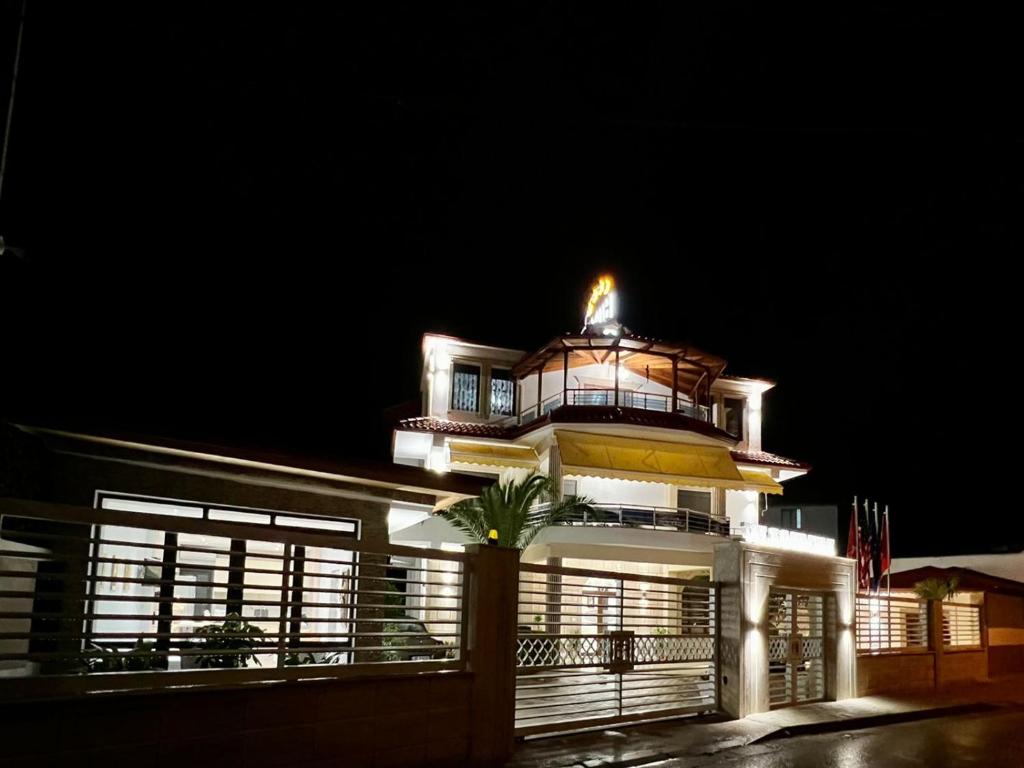 duży budynek z wieżą zegarową w nocy w obiekcie Hotel Vila Mimani w mieście Berat