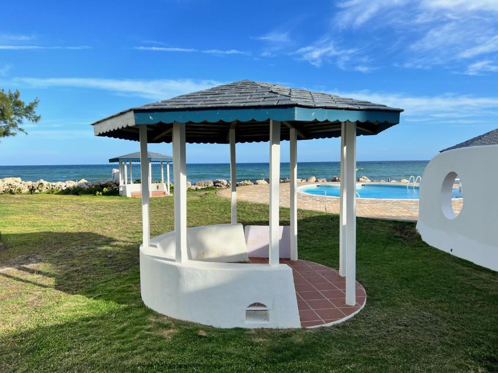 a gazebo sitting next to a swimming pool at OceanBlue Resort in Christ Church