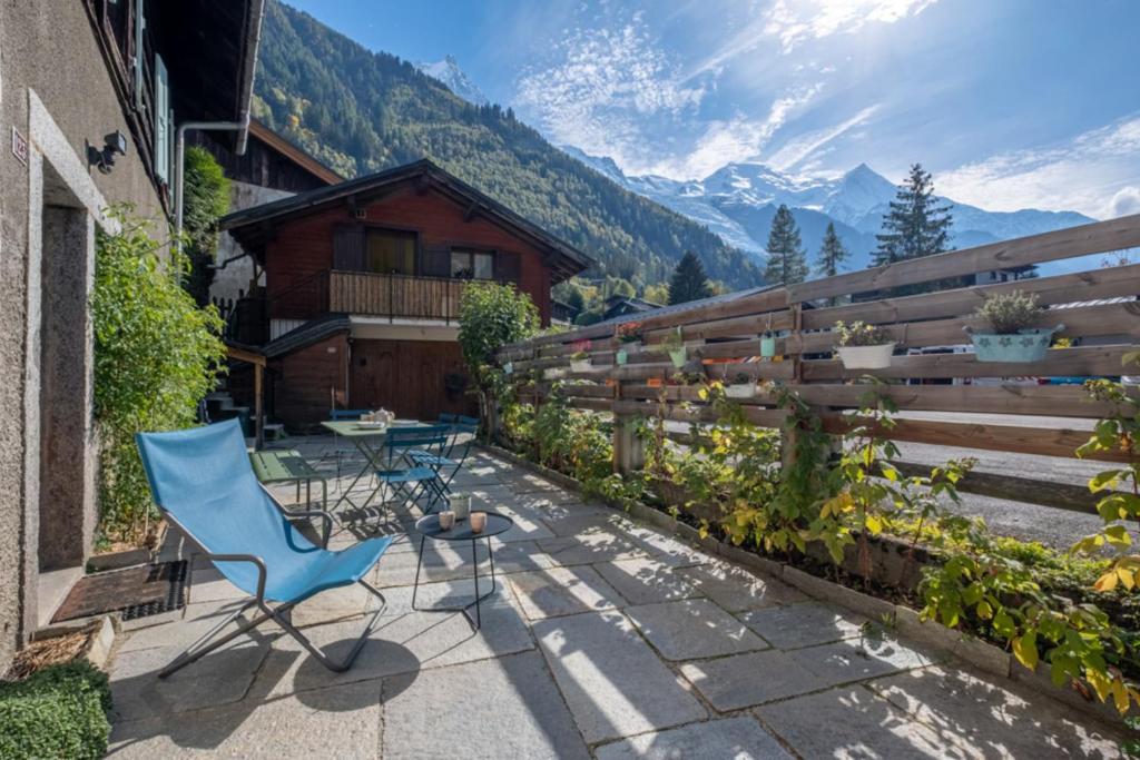 a patio with a blue chair and a table and a fence at Loft-chalet with exterior and view in Chamonix in Chamonix-Mont-Blanc