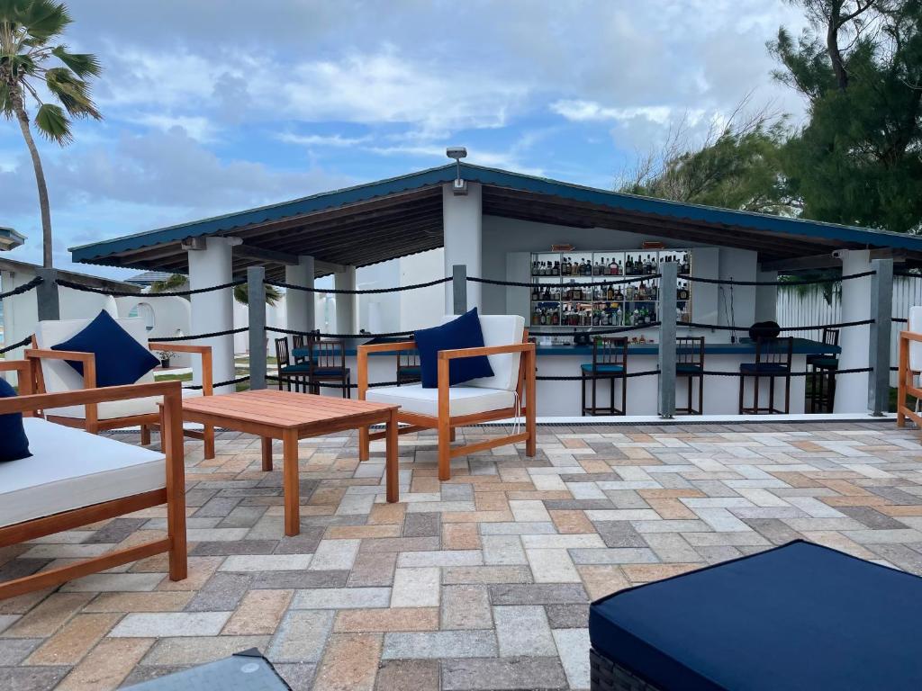 a patio with chairs and tables and a building at OceanBlue Resort in Christ Church