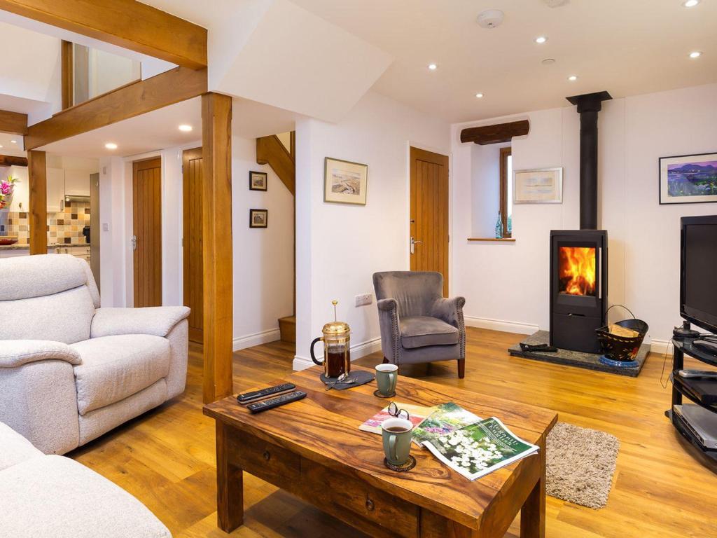 a living room with a coffee table and a fireplace at Willow Tree Barn in Kendal