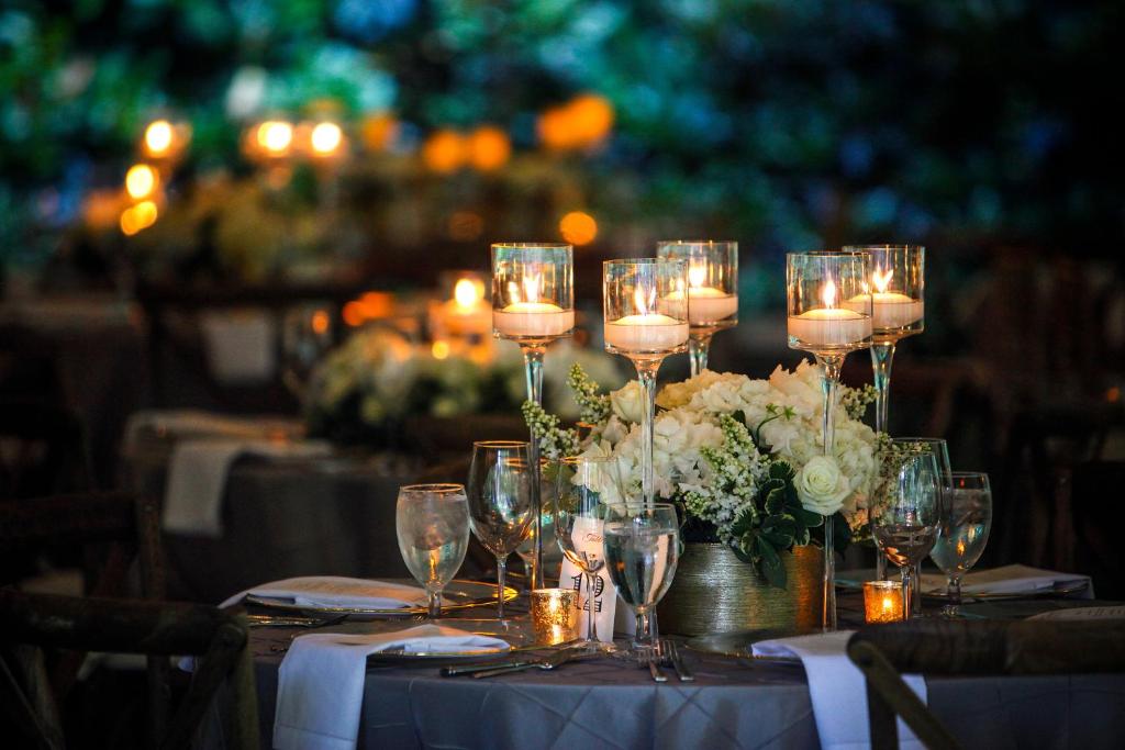stół ze świecami oraz białe kwiaty i szklanki w obiekcie Kimpton Alma San Diego, an IHG Hotel w mieście San Diego