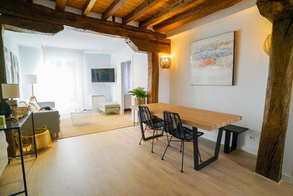 sala de estar con mesa de madera y sillas en Homely Rooms en Santander