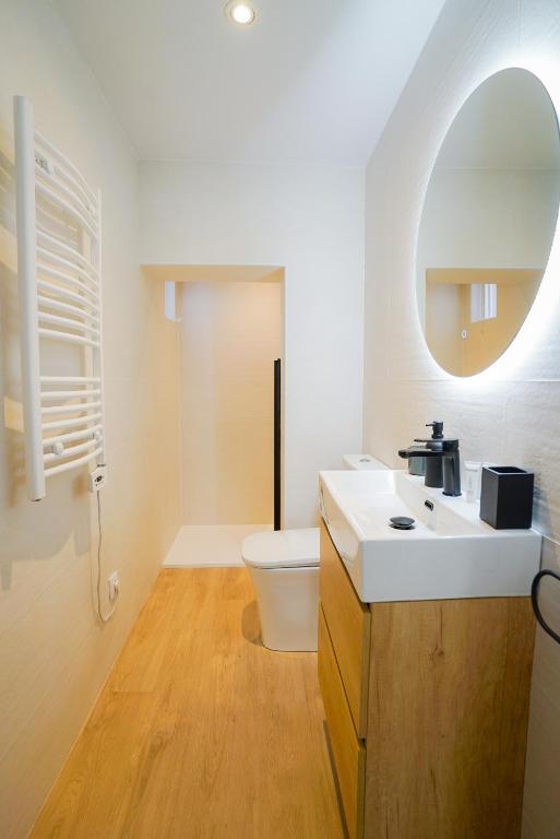 łazienka z umywalką, toaletą i lustrem w obiekcie Homely Rooms w mieście Santander