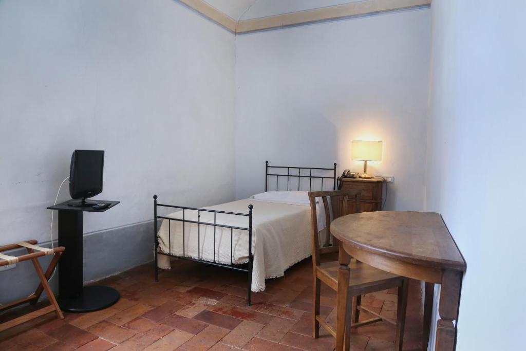 アレッツォにあるラ ロカンダ ディ サン ピエール ピッコロのベッドルーム1室(ベッド1台、テーブル、デスク付)