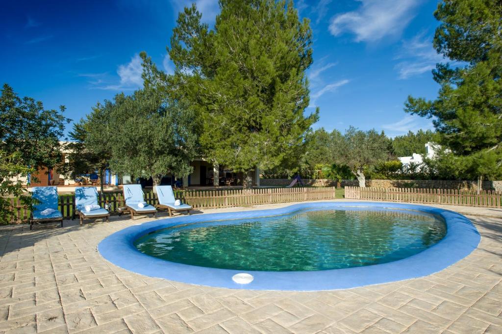 a swimming pool with two chairs and a fence at Casa Carla in Ibiza Town