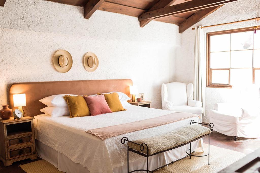 a bedroom with a large bed and a chair at Cacao Boutique Hotel in Antigua Guatemala