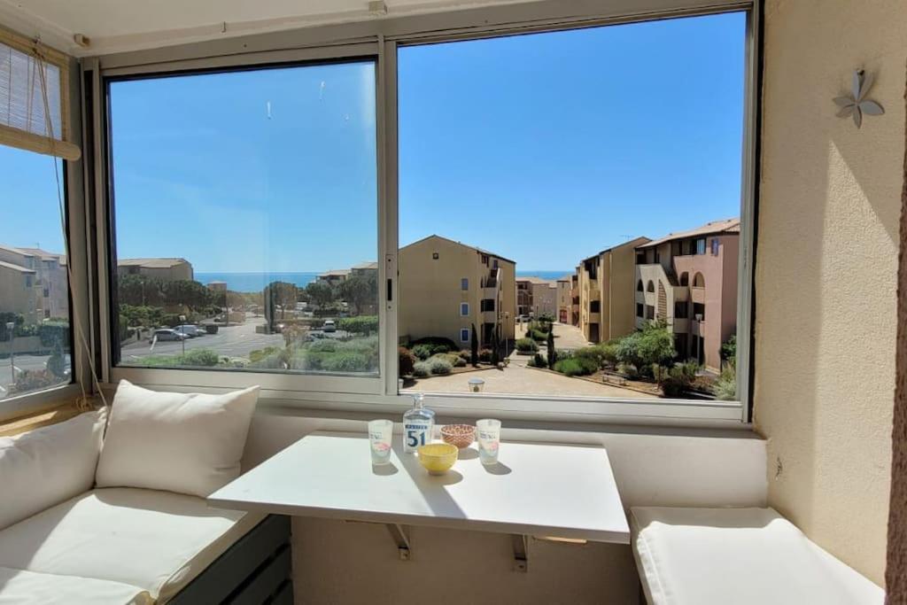 - une table blanche dans une chambre avec une grande fenêtre dans l'établissement Appartement vue mer climatisé Seaview AC apartment Saint Pierre la Mer, à Fleury