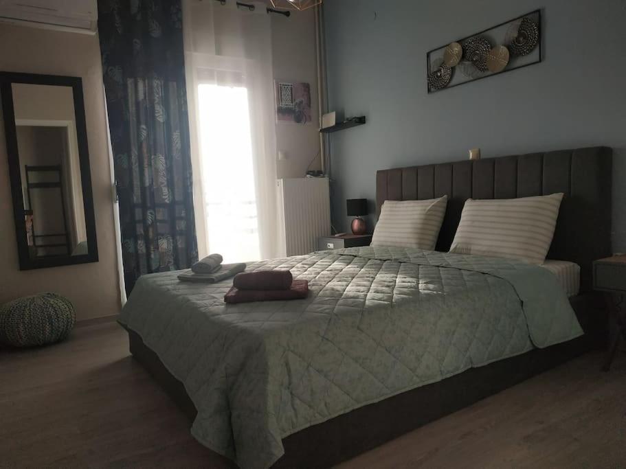 Un dormitorio con una cama grande y una ventana en Athens view apartment near Metro station Agia Marina, en Atenas