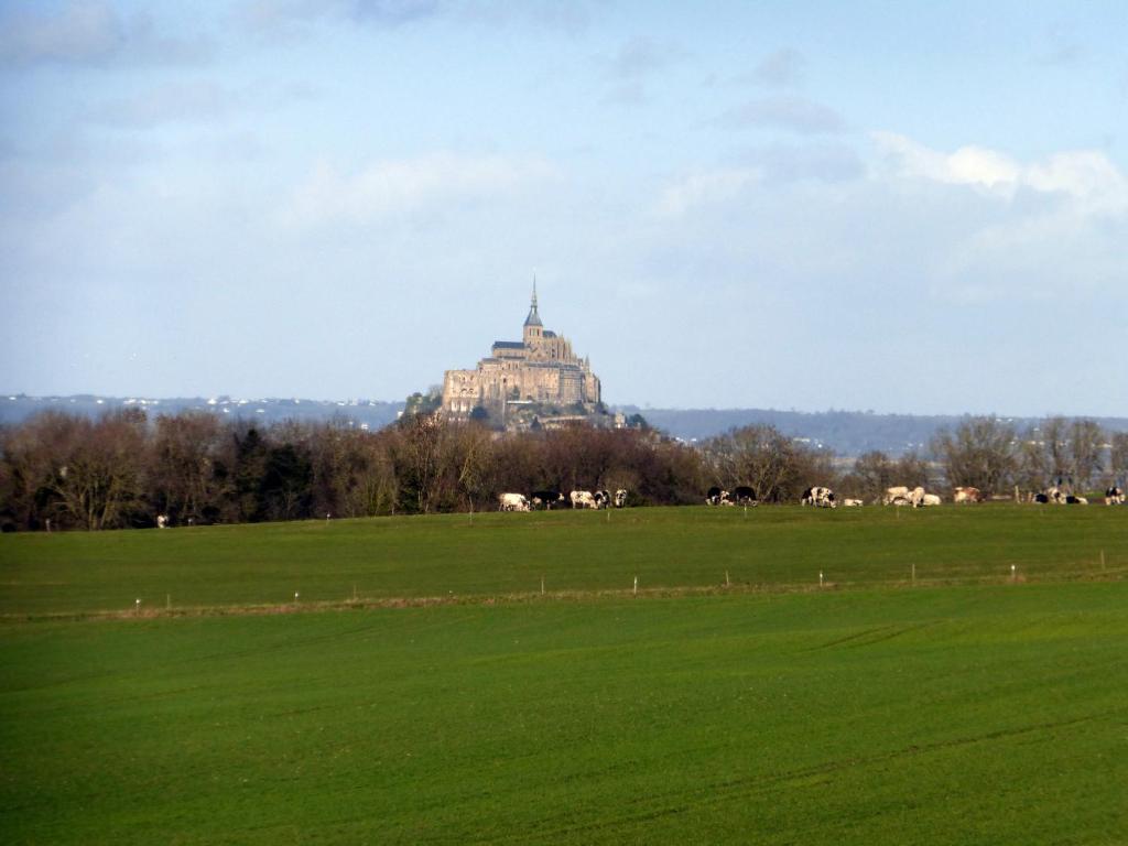 a large building on top of a green field at Hotel De France in Pontorson