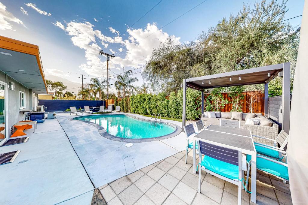a patio with a pool and a table and chairs at The Sunny Spot Permit# 5084 in Palm Springs