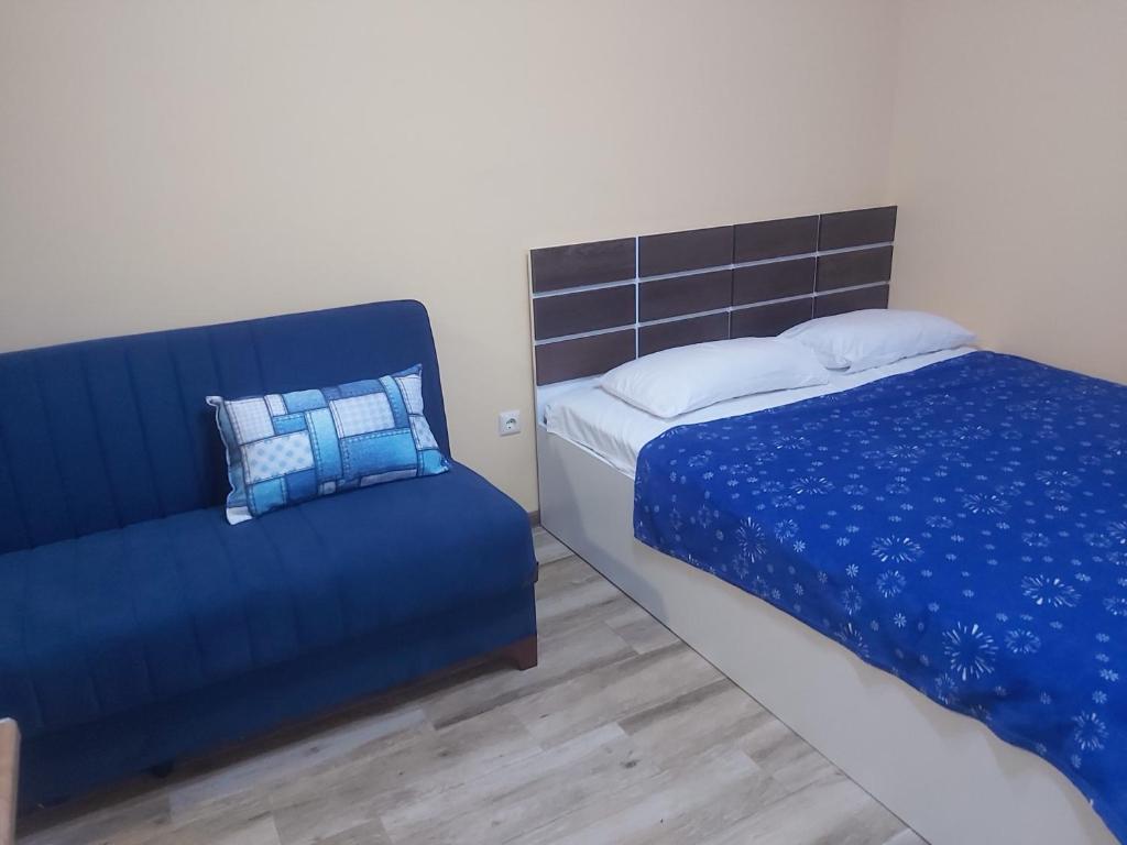 ein Schlafzimmer mit einem Bett und einem Sofa in der Unterkunft Студия с красивым видом на горы in Batumi