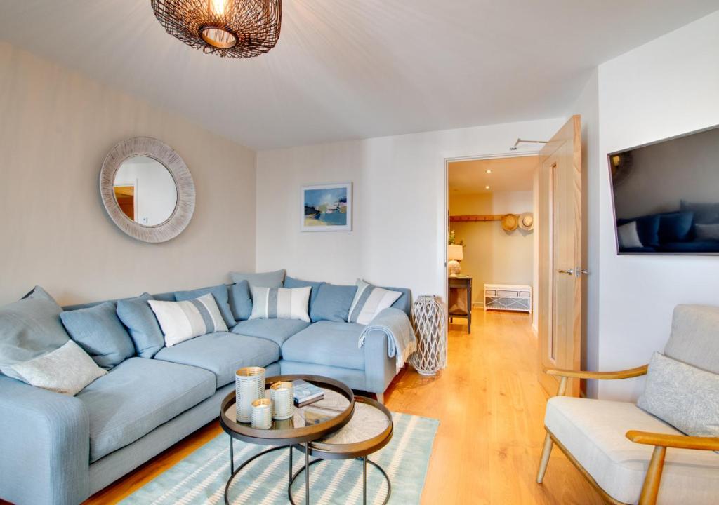 uma sala de estar com um sofá azul e uma mesa em West Bay Watch em West Bay