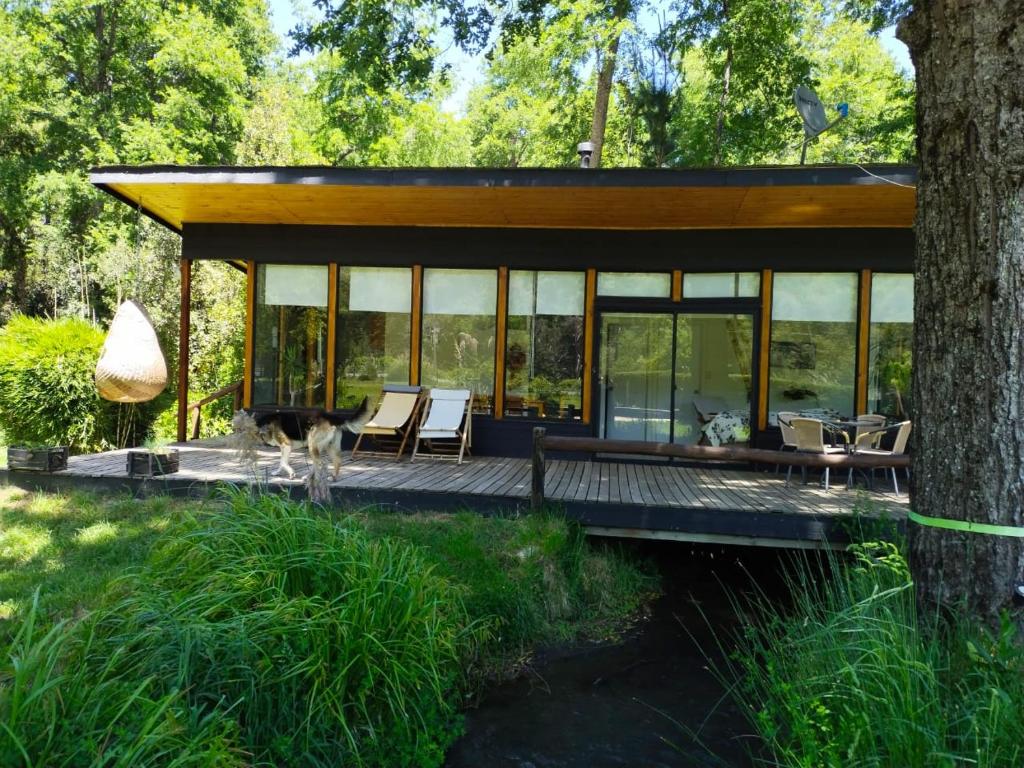 a house in the woods with a large deck at Cabañas Nordic lodge in Chillán