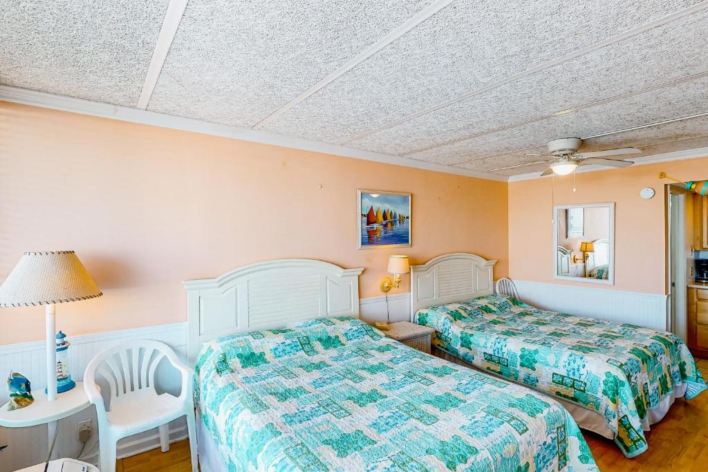 a bedroom with two beds and a table and chair at Shorely Suite in Atlantic Beach