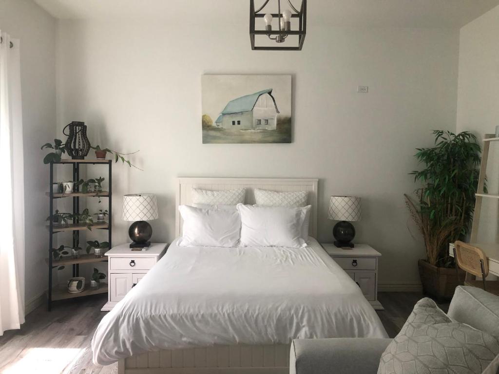 a bedroom with a white bed and a couch at Beautiful Private Casita/Guesthouse w/ Kitchen, Access to Pool/Spa in Goodyear