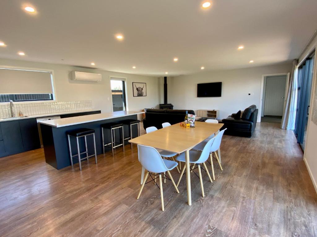 uma sala de jantar e cozinha com mesa e cadeiras em Stylish, Tasteful in Totara em Twizel