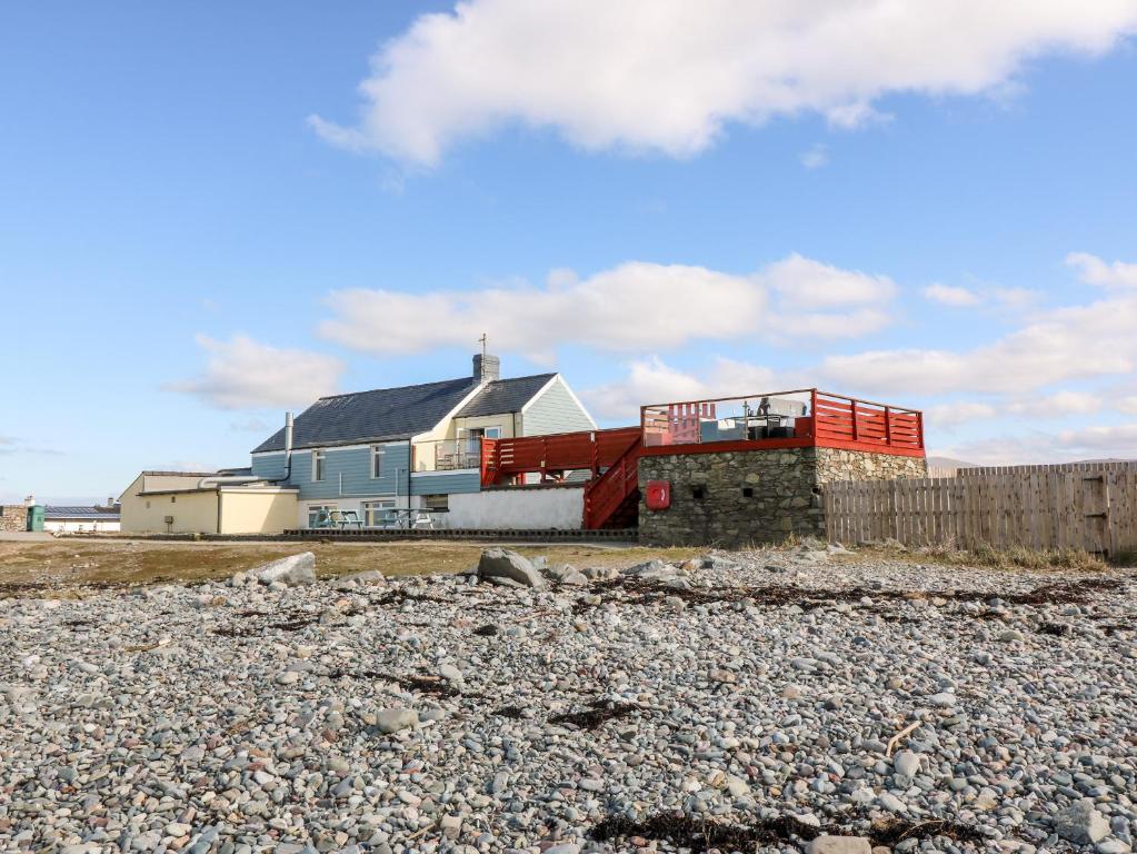 a house on the beach with a rocky ground at Swn Y Mor in Caernarfon