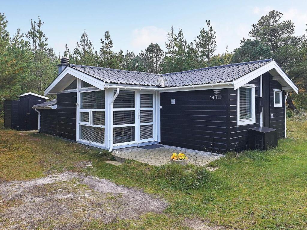 Sønder Vorupørにある5 person holiday home in Thistedの玄関と扉のある黒小屋