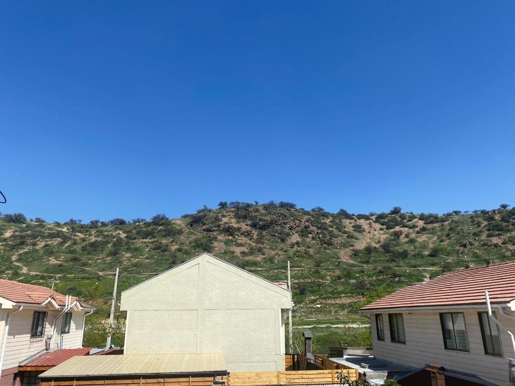 une maison blanche avec une montagne en arrière-plan dans l'établissement CASA AGRADABLE, à Santiago