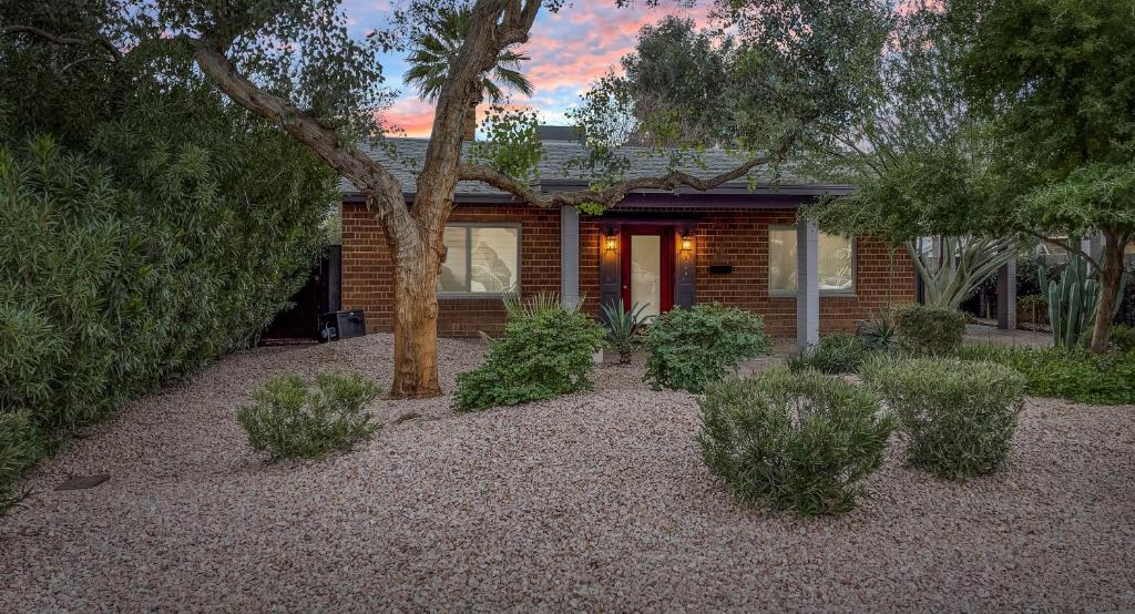 uma casa com uma árvore e arbustos em frente em Casa Del Luna in Biltmore em Phoenix
