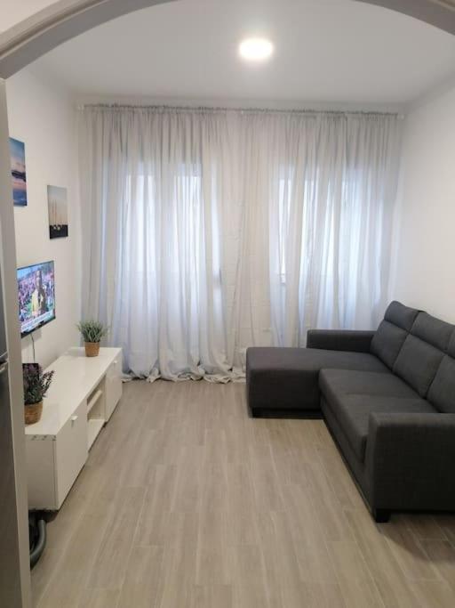 a living room with a couch and a tv at Casa Peixe Nazare in Nazaré