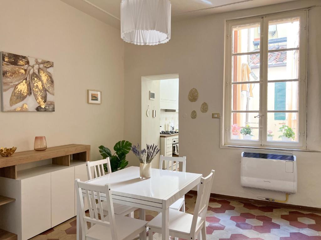 biała jadalnia z białym stołem i krzesłami w obiekcie Civico 41 Lucca City Center Apartment w Lukce