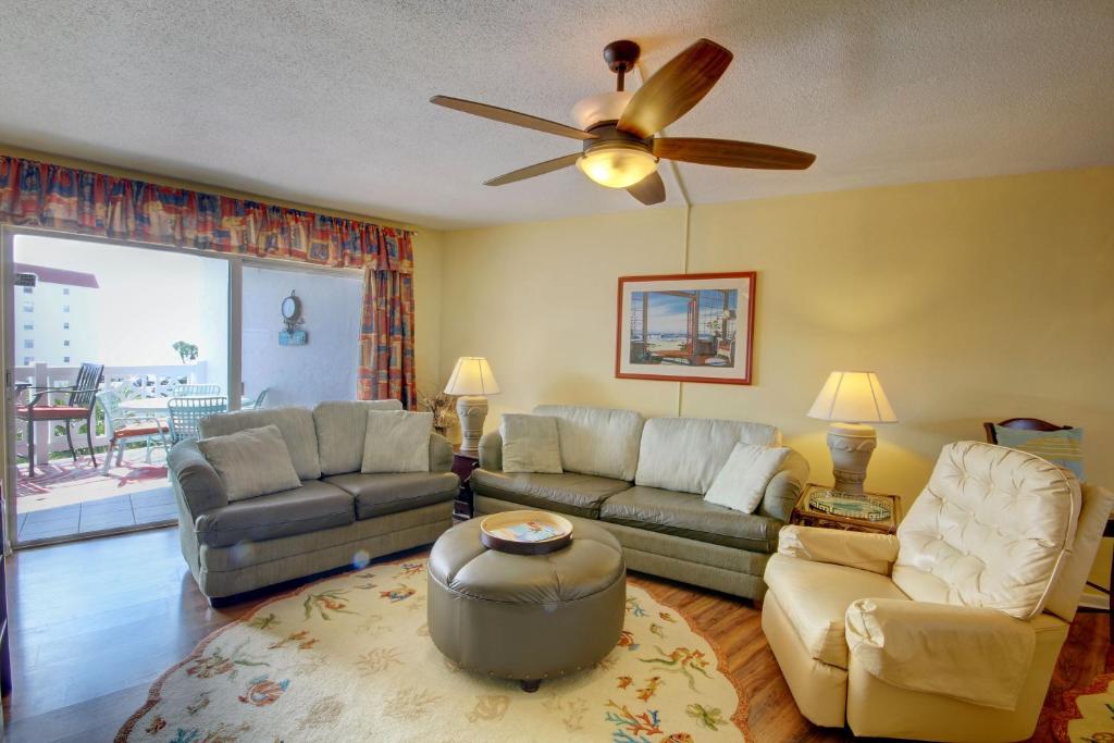 a living room with a couch and a ceiling fan at El Matador 145 - Centrally located with a view of the Gulf in Fort Walton Beach
