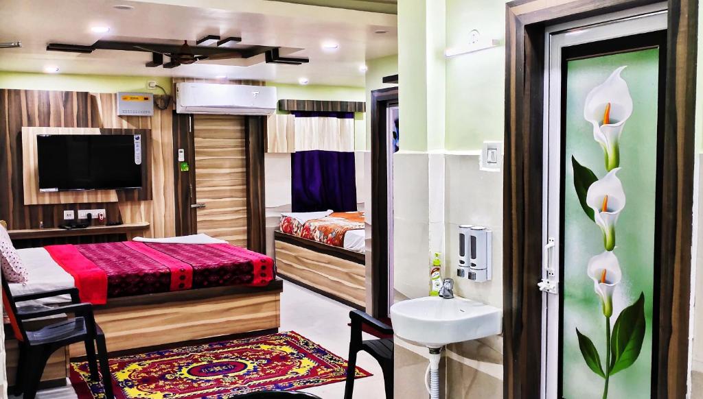 a room with a bathroom with a bed and a sink at LN BEACH Homestay in Puri