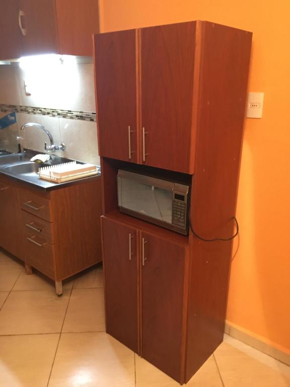 cocina con armario y microondas en Cami III en Piriápolis