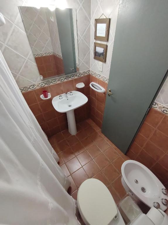 a bathroom with a white toilet and a sink at Costa Norte Hostería in Colón