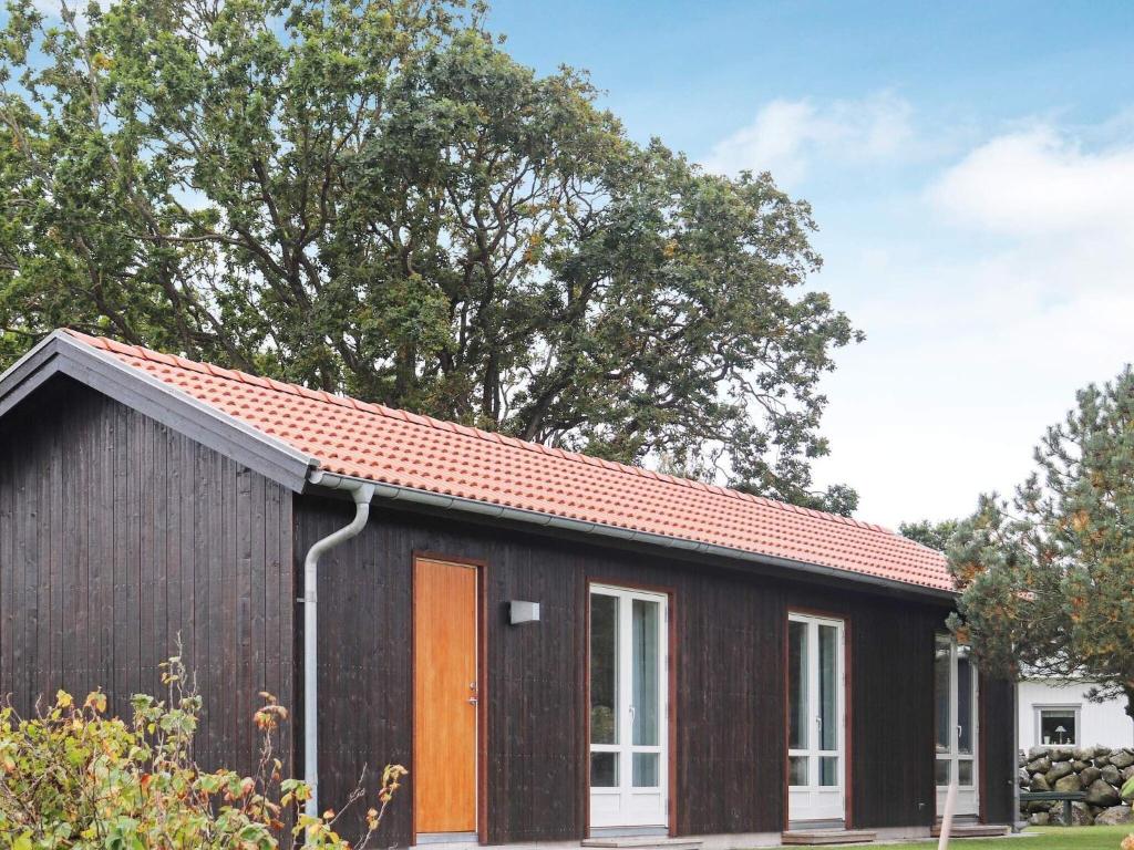 a small black house with an orange door at 4 person holiday home in TRÄLÖVSLÄGE-By Traum in TrÃ¤slÃ¶vslÃ¤ge
