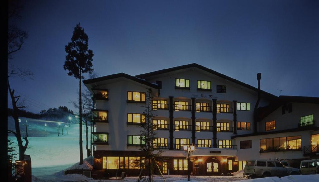 a large building with many windows at night at Petit Hotel Shitaka in Hakuba