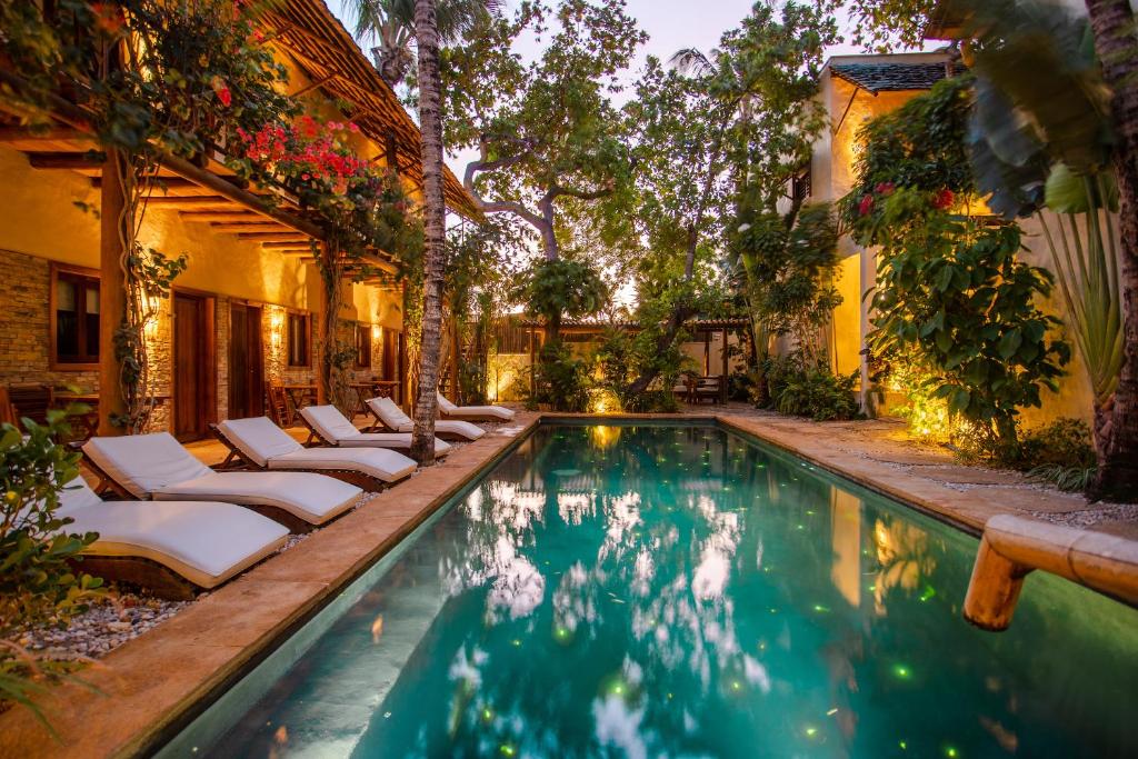 uma piscina com espreguiçadeiras ao lado de uma casa em CasaLô Hotel em Jericoacoara