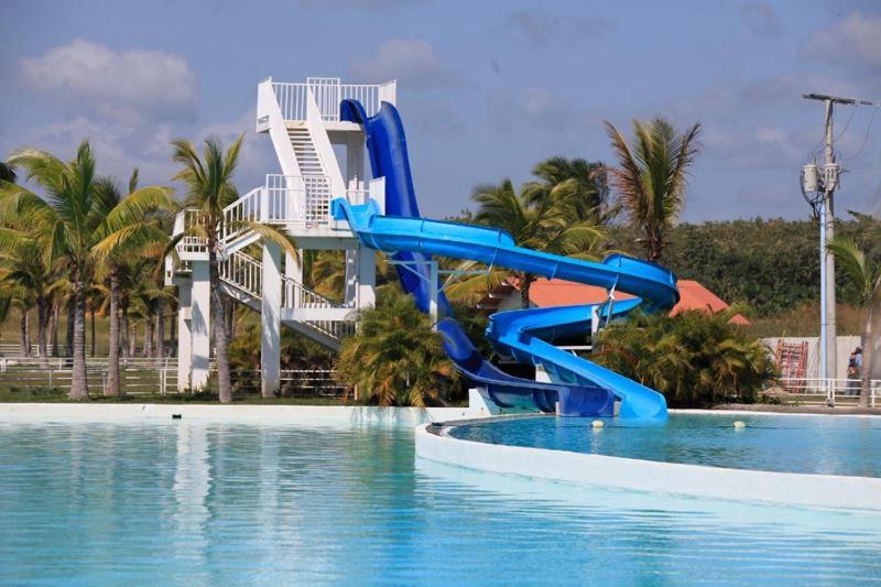 niebieska zjeżdżalnia na środku basenu w obiekcie Playa Blanca Town Center w mieście Río Hato