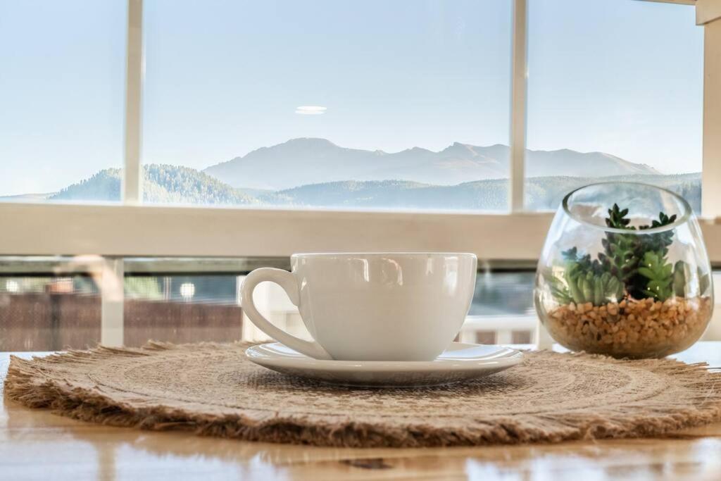 a coffee cup and a vase on a table at NEW! Boutique TinyHome w/Direct View of PikesPeak! in Woodland Park
