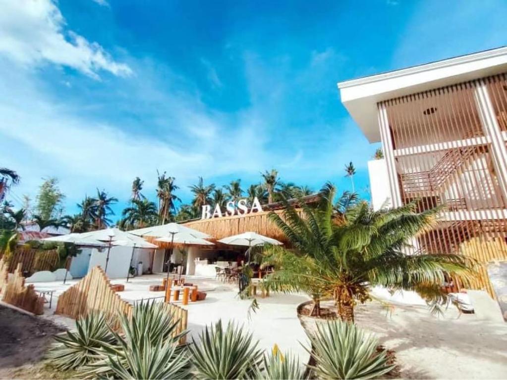 un complejo en la playa con palmeras y sombrillas en Bassa nova villa en Panglao