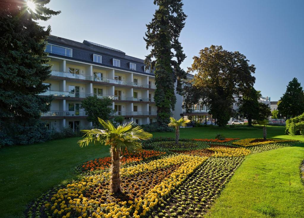 a building with a flower garden in front of it at At the Park Hotel in Baden