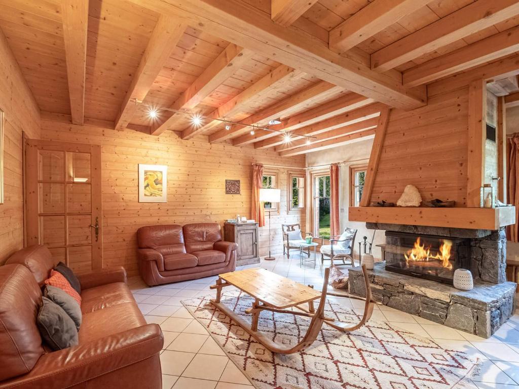 un salon avec un canapé et une cheminée dans l'établissement Chalet de charme à Chamonix, 6 chambres, jardin, parking, wifi - FR-1-343-226, à Chamonix-Mont-Blanc
