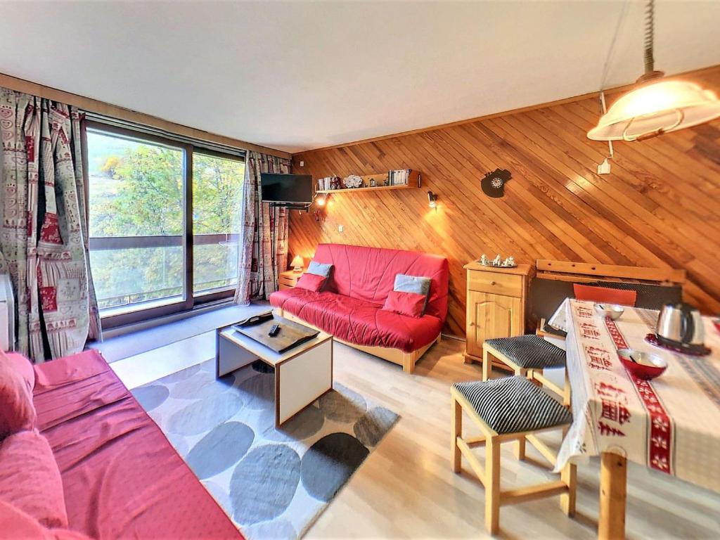 un salon avec un canapé rouge et une table dans l'établissement Studio confortable skis aux pieds avec balcon, piscine chauffée - FR-1-267-242, à Villarembert