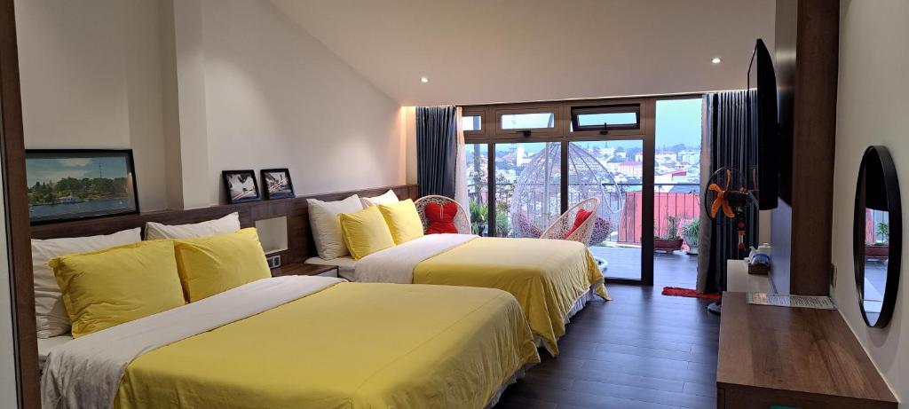 een hotelkamer met 2 bedden met gele lakens bij Ánh Dương House in Da Lat